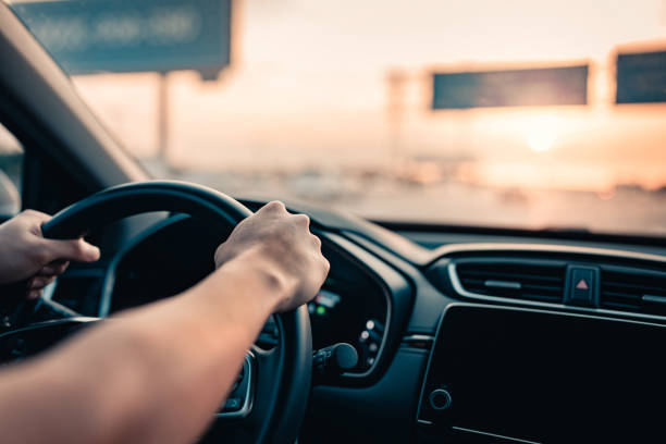 Close-up – Hand of man driving car on the road.